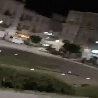 Urso passeia à noite no centro de Przemyśl, Polónia