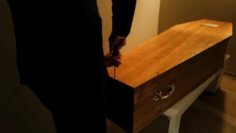 ARQUIVO: Franck Vasseur, agente funerário em Paris, sela um caixão numa morgue parisiense, com a ajuda dos carregadores Louis Mercier e Allan Pottier, 24.04.20