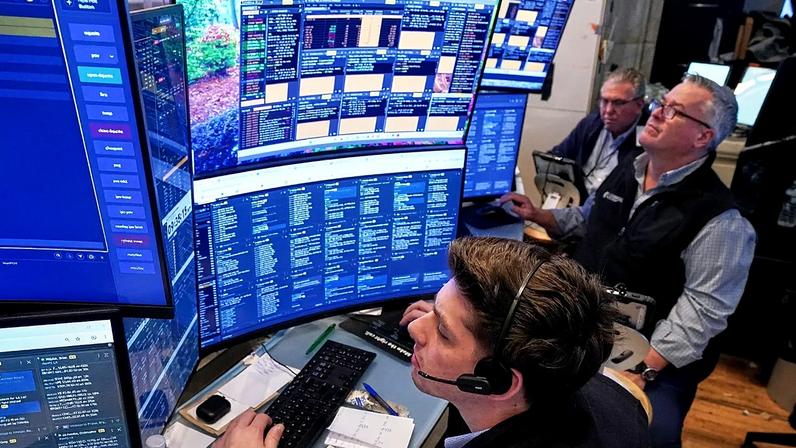 Três operadores trabalham no piso da Bolsa de Nova Iorque, 3 de junho de 2026