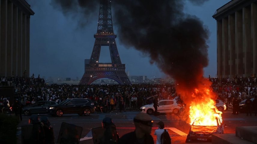 Carro arde enquanto adeptos do PSG celebram em Paris, sábado, 30 de maio de 2026