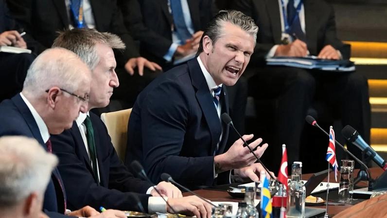 Secretário da Defesa dos EUA Pete Hegseth discursa numa reunião de ministros da Defesa na sede da NATO, em Bruxelas, a 18 de junho de 2026