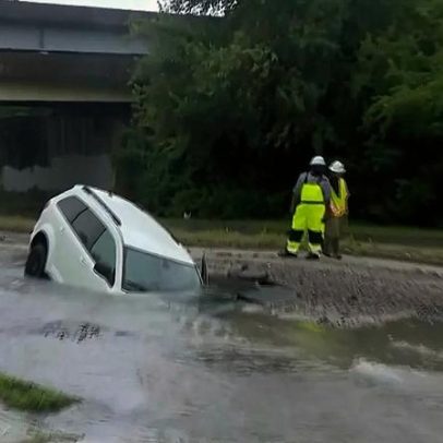 Carro cai em cratera inundada; mulher é resgatada