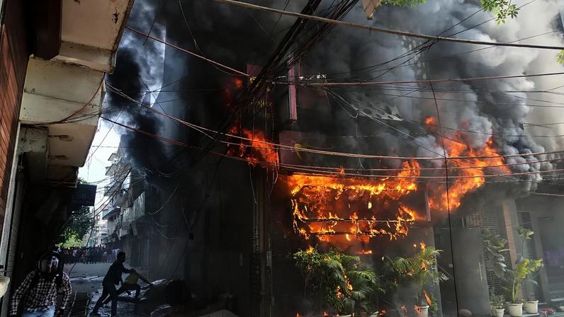 Moradores tentam apagar um incêndio num hotel em Nova Deli, Índia, quarta-feira, 3 de junho de 2026