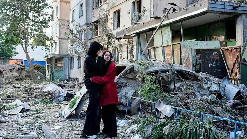 Pessoas reagem enquanto observam o local de um ataque com míssil russo que atingiu um prédio residencial em Kiev, Ucrânia, terça-feira, 2 de junho de 2026.