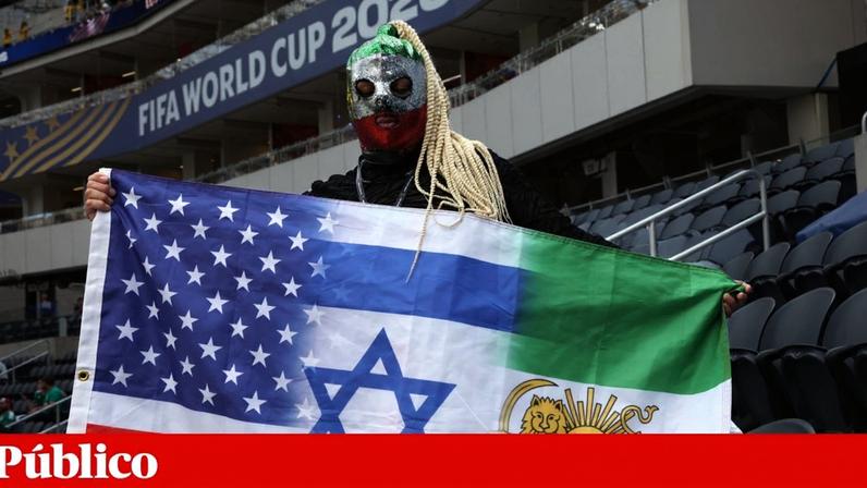 Um adepto segura uma bandeira que combina os símbolos dos Estados Unidos, o “Leão e Sol” pré-Revolução Islâmica e Israel, no interior do estádio antes do jogo