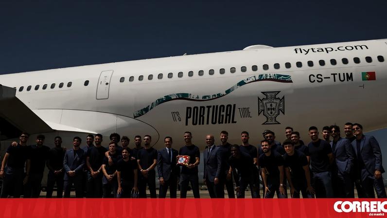 Jogadores posam em frente ao avião da TAP com apoio a Portugal, na pista do Aeroporto de Lisboa