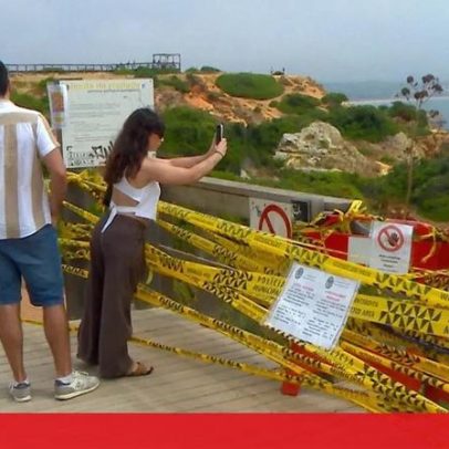 Turistas descem escadas para a praia do Camilo em Lagos apesar de perigo