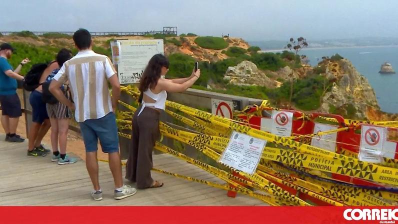 Turistas descem escadas para a praia do Camilo em Lagos apesar de perigo
