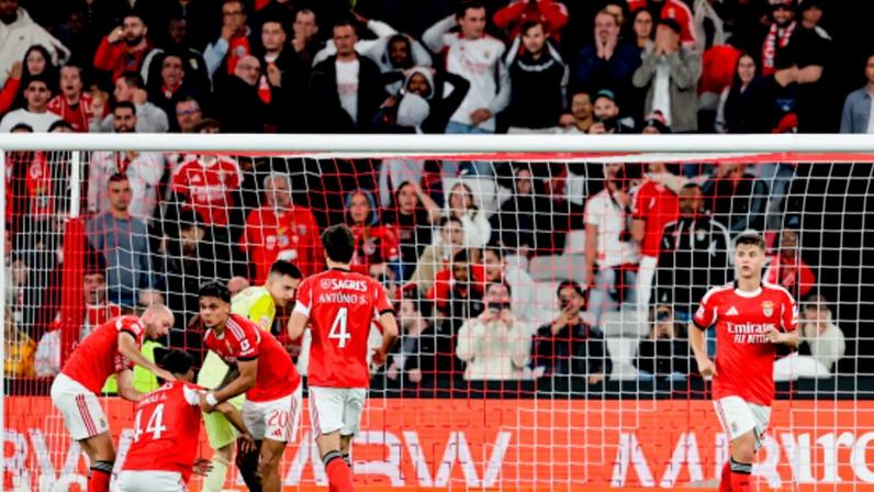 Jogadores do Benfica junto à baliza celebram autogolo durante jogo da I Liga