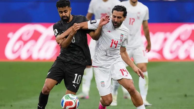 Sarpreet Singh (à esquerda) numa disputa de bola com Saman Ghoddos, da seleção do Irão