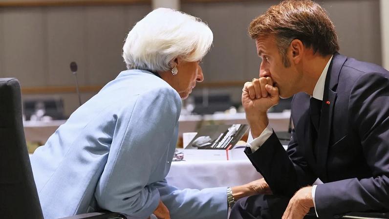 Christine Lagarde (à esquerda), presidente do Banco Central Europeu, fala com Emmanuel Macron durante jantar de trabalho da cimeira do Euro em Bruxelas, outubro 2025