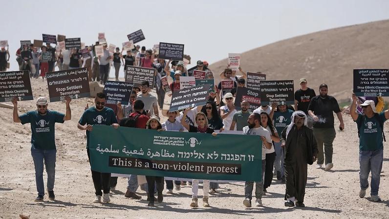 Ativistas israelitas e internacionais pela paz manifestam-se em apoio às comunidades beduínas de Khan al-Ahmar, na Cisjordânia ocupada, sexta-feira, 12 de junho de 2026.